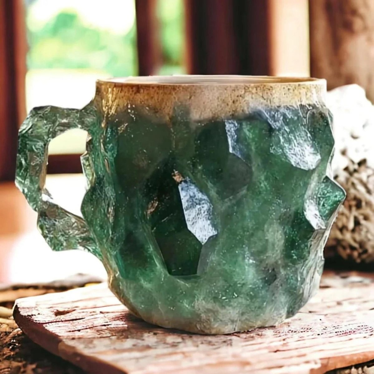 Detailed close-up of a handcrafted emerald green crystal geode mug with a ceramic rim, resting on a rustic wooden surface.