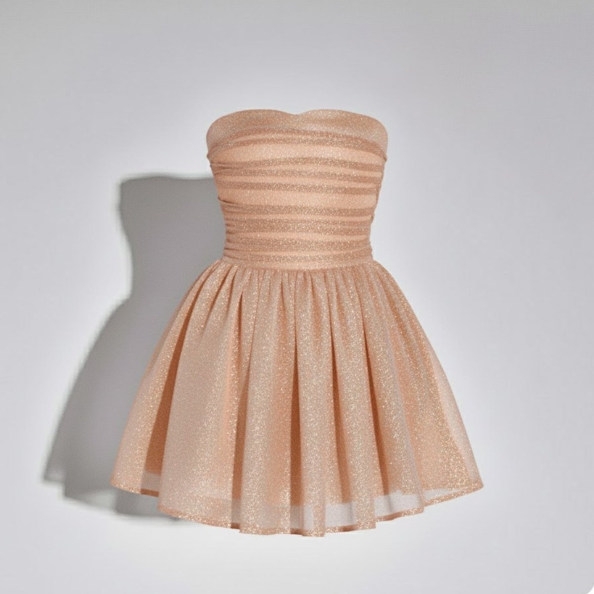Front product view of the Kouvr Harmoni apricot strapless cocktail dress on a hanger against a white background.
