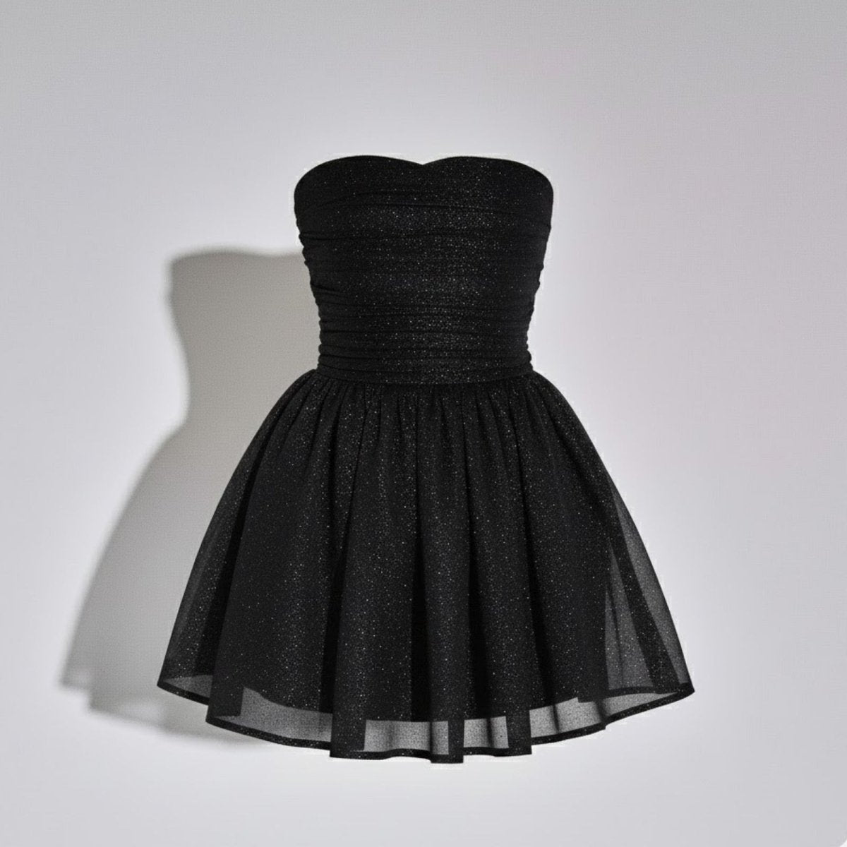 Product-only photo of the Kouvr black glitter strapless dress on a mannequin, showing the ruched bodice and A-line skirt.