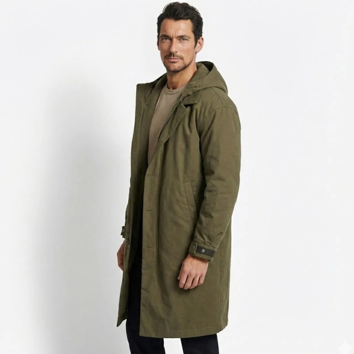 Side profile of a man in the army green Kouvr Hartley hooded parka, showing its length and fit.
