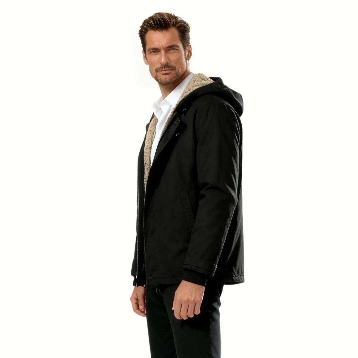 Side profile of a man in the Kouvr Honovi black insulated parka showing the fit and sherpa hood detail.