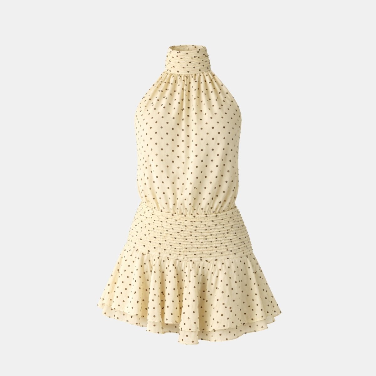 Flat lay of a beige polka dot halter mini dress featuring a high mock neck, smocked waistband, and tiered ruffle hem.