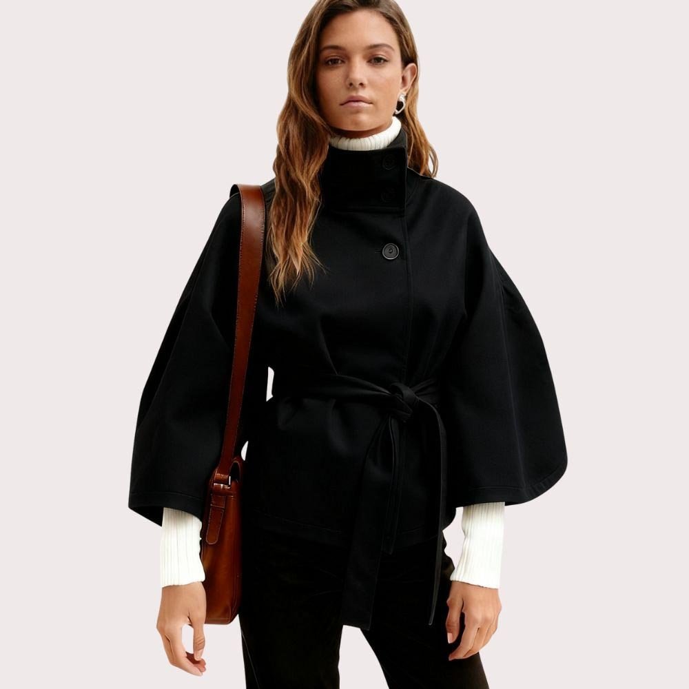 Model wearing Kouvr Fashion belted cape jacket with funnel neck and wide kimono sleeves