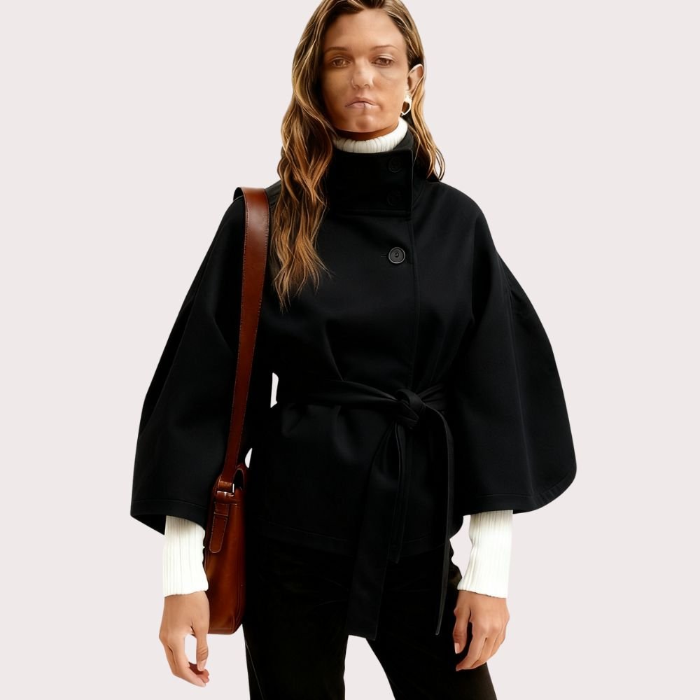 Model from behind wearing the black Kouvr Jaye Cape Jacket, showcasing the tie-back belt and wide kimono sleeves