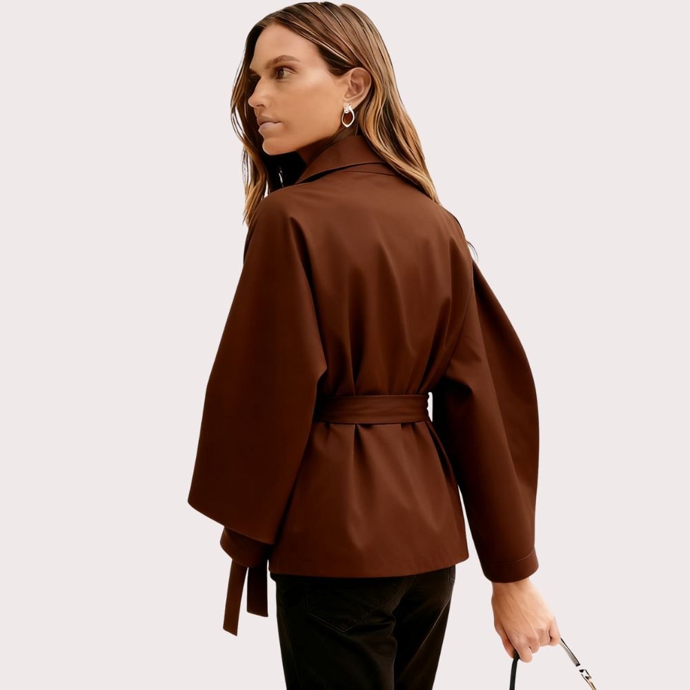 Model from the back wearing the Kouvr Jaye Belted Cape Jacket in Tobacco Brown, showcasing the wide sleeves and tie-waist detail