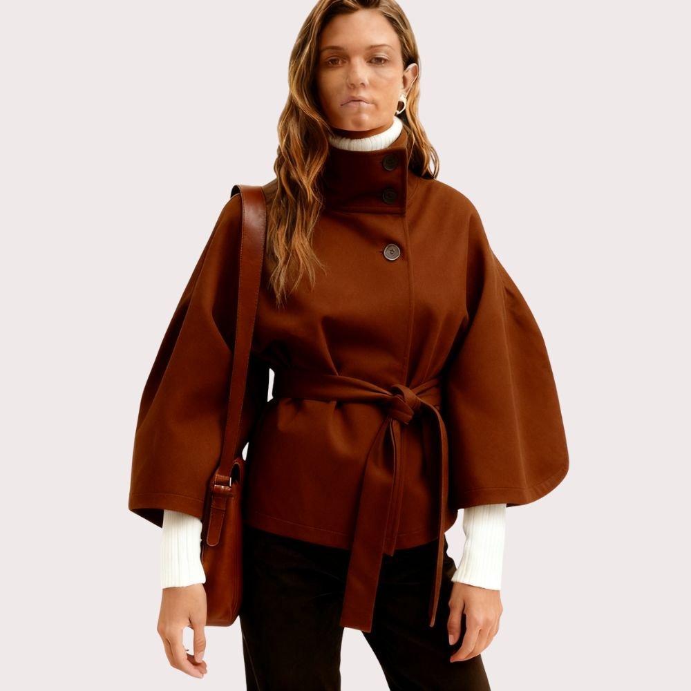 Model from the back wearing the Kouvr Jaye Belted Cape Jacket in Tobacco Brown, showcasing the wide sleeves and tie-waist detail