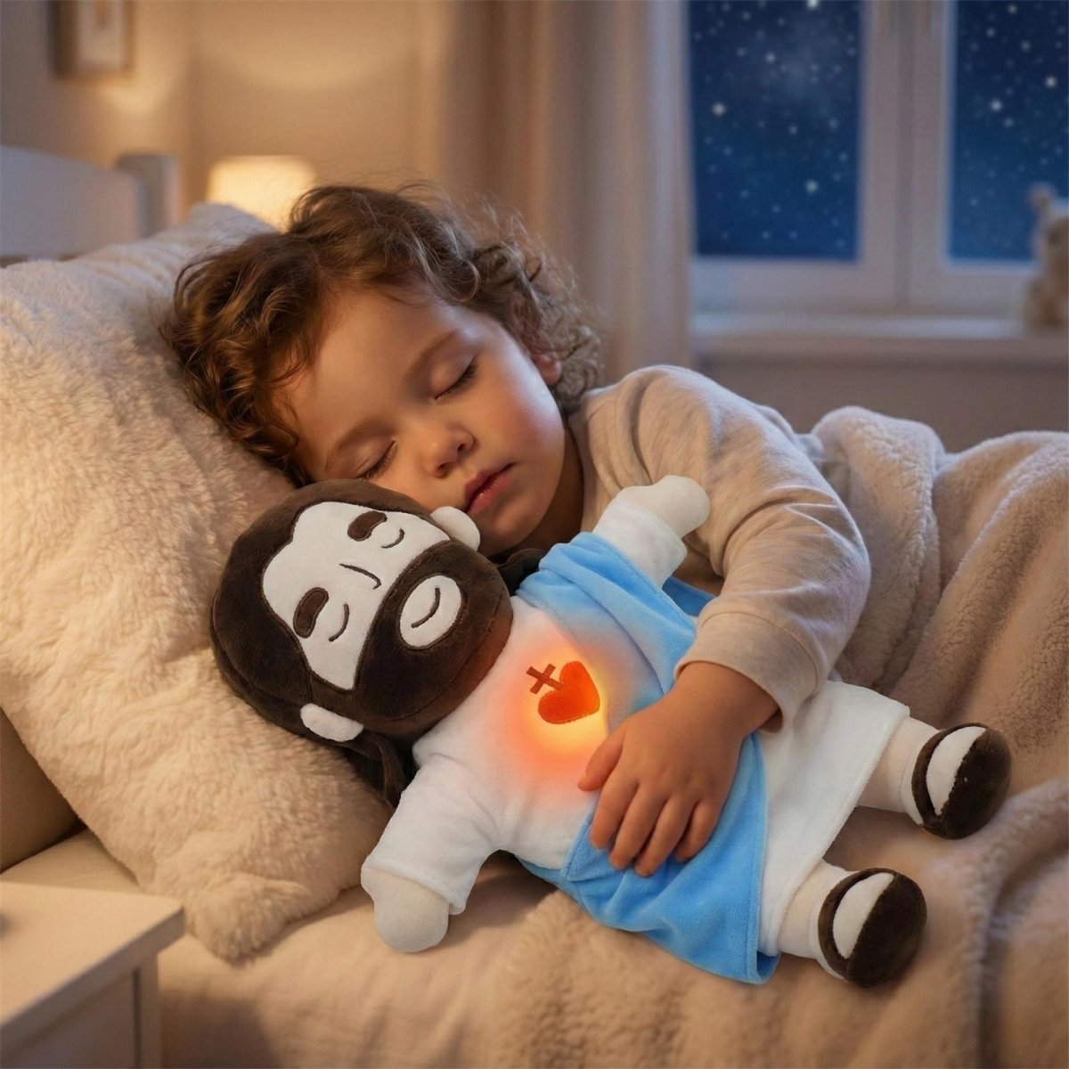 A young toddler sleeping peacefully in bed while hugging the Kouvr My First Jesus Plush Toy with its warm, glowing heart.