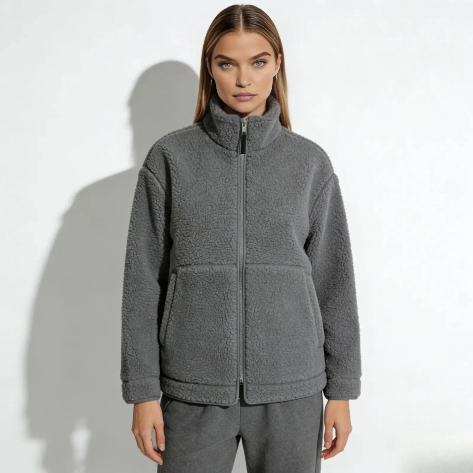 Model wearing the Kouvr Fashion Julie oversized sherpa fleece jacket gray, zipped up to the high neck, showing the front patch pockets