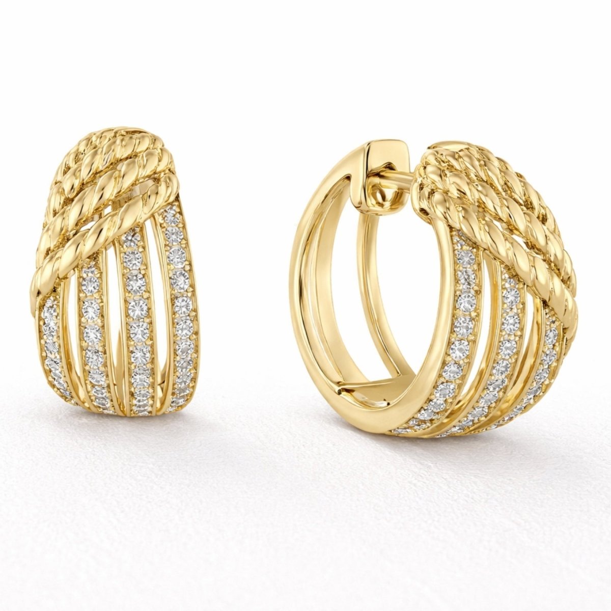 A pair of Kouvr Kalista 18k yellow gold chunky huggie hoop earrings with three rows of pave diamonds and a twisted rope detail on a white background.