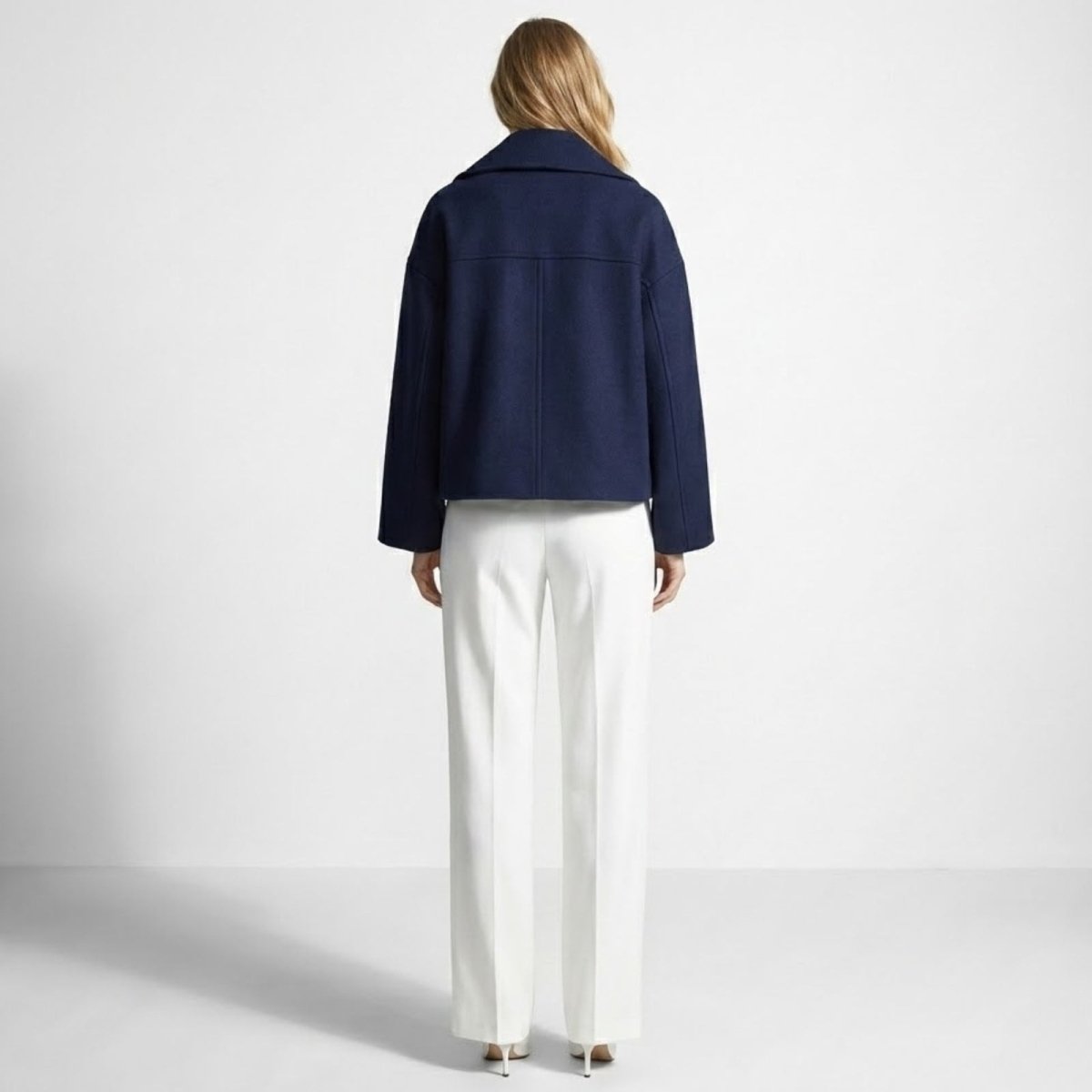Back view of the Kouvr Katherine navy cropped peacoat, highlighting the clean lines of the structured back yoke and minimalist design.
