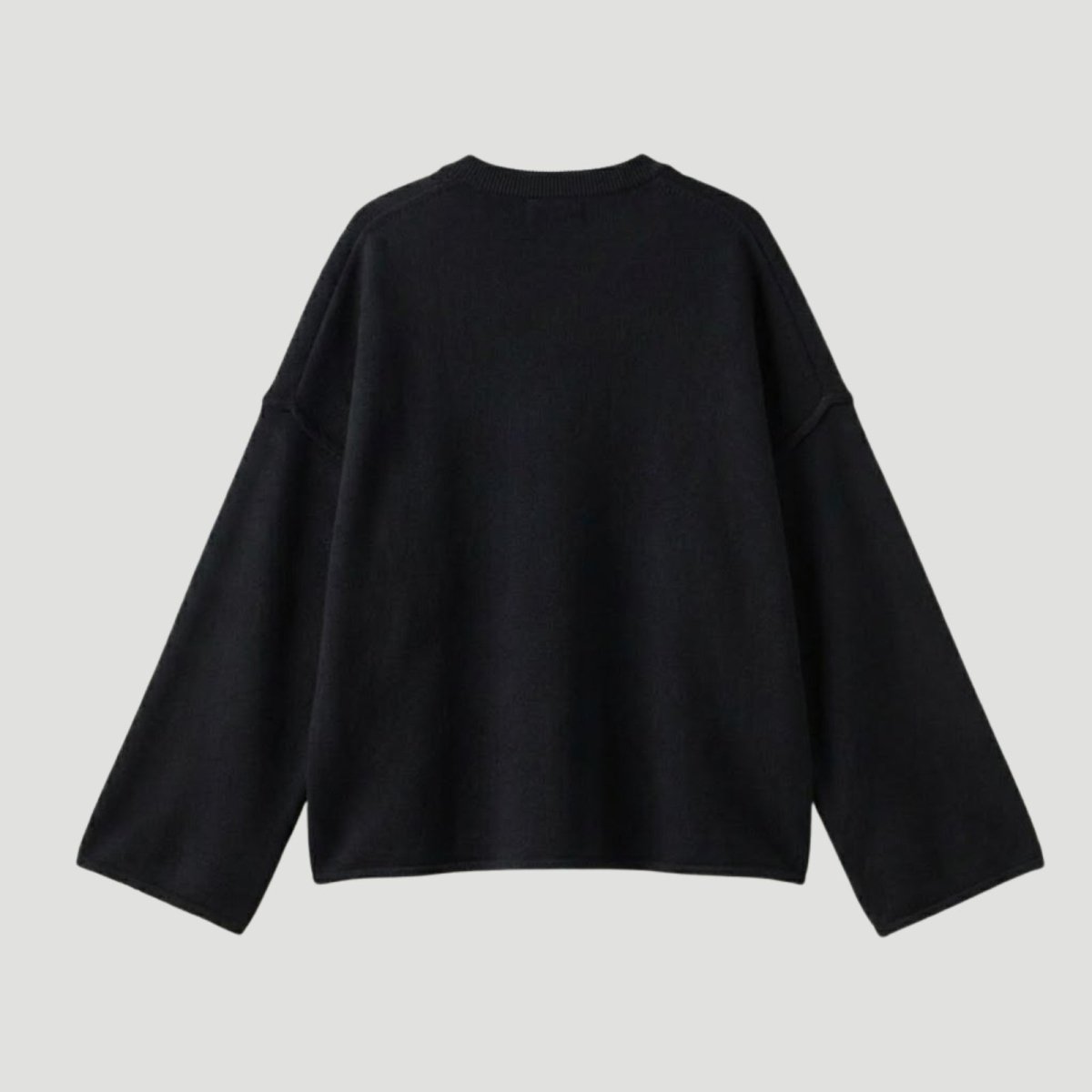 Back view of a black oversized knit pullover showing the texture of the fabric and the minimalist design for women's luxury fashion.