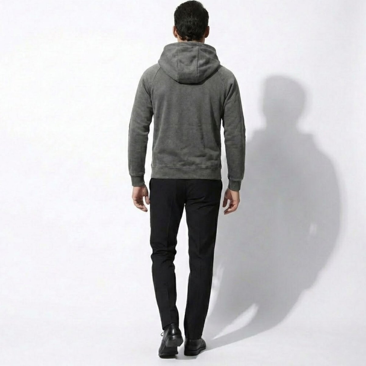 Back view of a male model wearing the Kouvr grey hoodie showing the fit and hood shape.