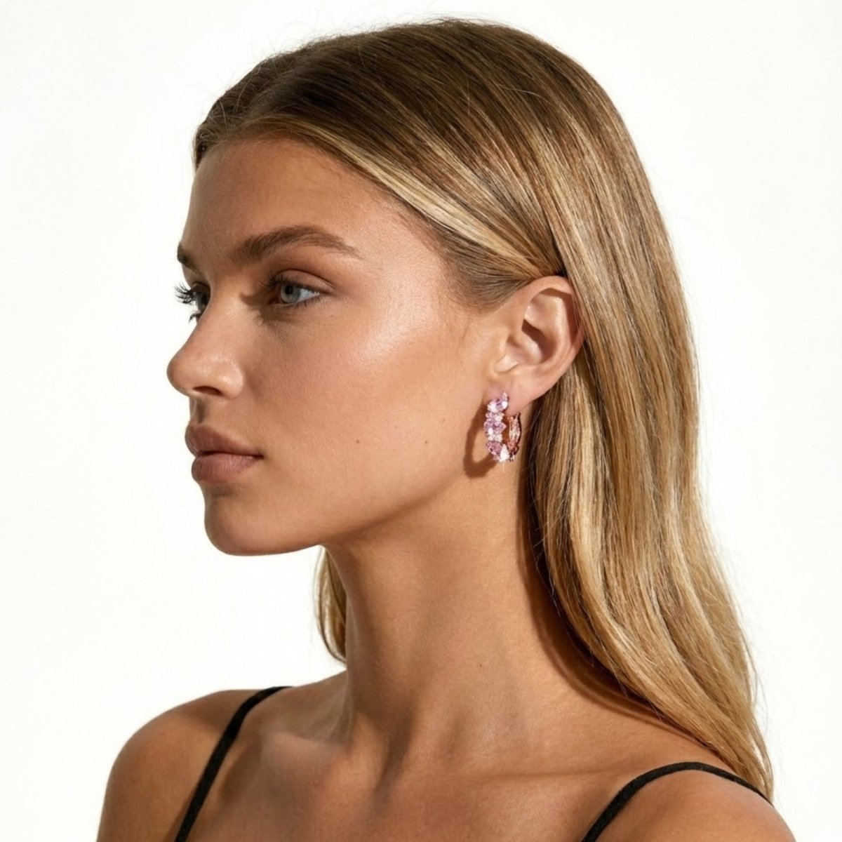 Side profile of a model showcasing the Kouvr Laliana pink sapphire and rose gold cluster huggie earring in her ear.
