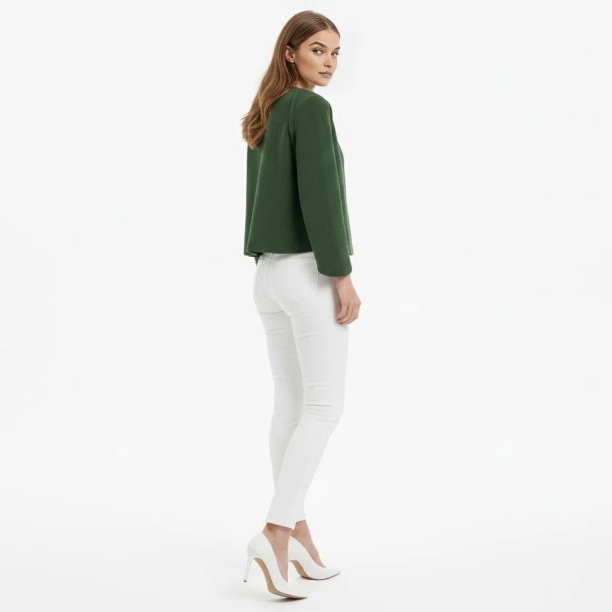 Back view of a model in the Kouvr Laverne dark green jacket, highlighting the clean lines and minimalist design.
