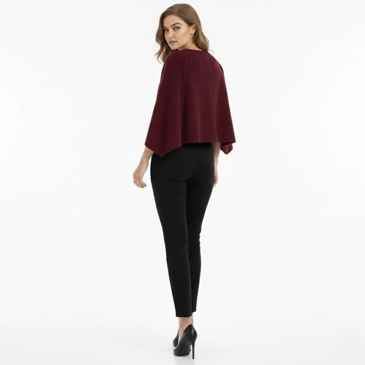 Back view of a woman in the Kouvr Laverne Structured Capelet, highlighting the clean lines and tailored shoulders.