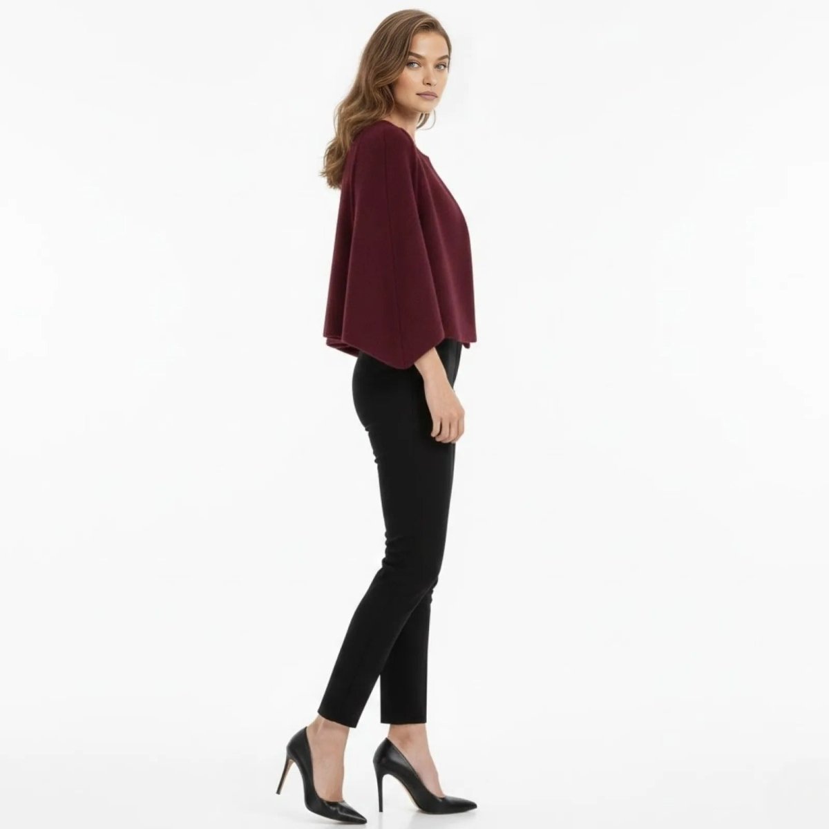 Side profile of a woman wearing the Kouvr Laverne Structured Capelet, showing the elegant drape of the cape sleeve.