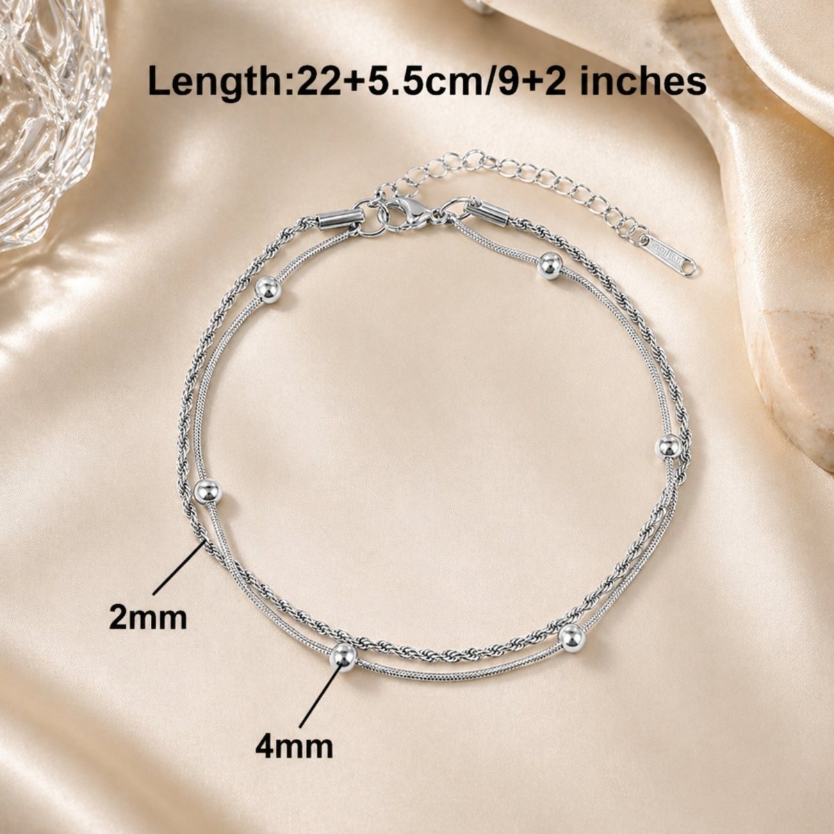 A diagram showing the measurements of the Kouvr silver anklet: 2mm chain width, 4mm bead size, and 22cm length with a 5.5cm extender.