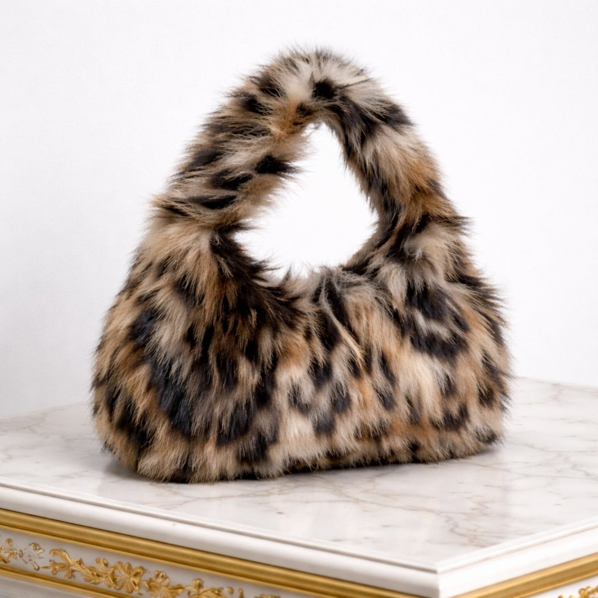 The Kouvr Lenora soft animal print bag sitting on a white marble console table, showcasing its luxurious texture.