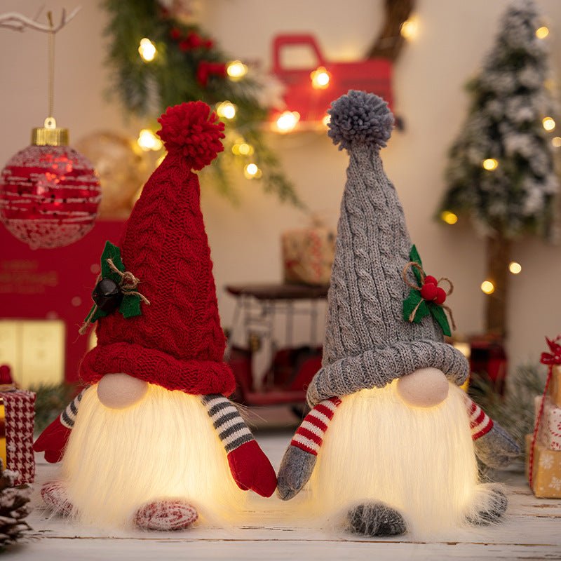 Close-up of two glowing Kouvr holiday gnome figurines holding hands, highlighting the texture of their knit hats and soft, illuminated beards.