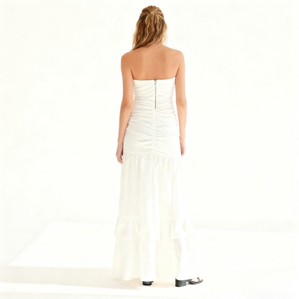 Woman wearing a strapless white Kouvr gown on a white background