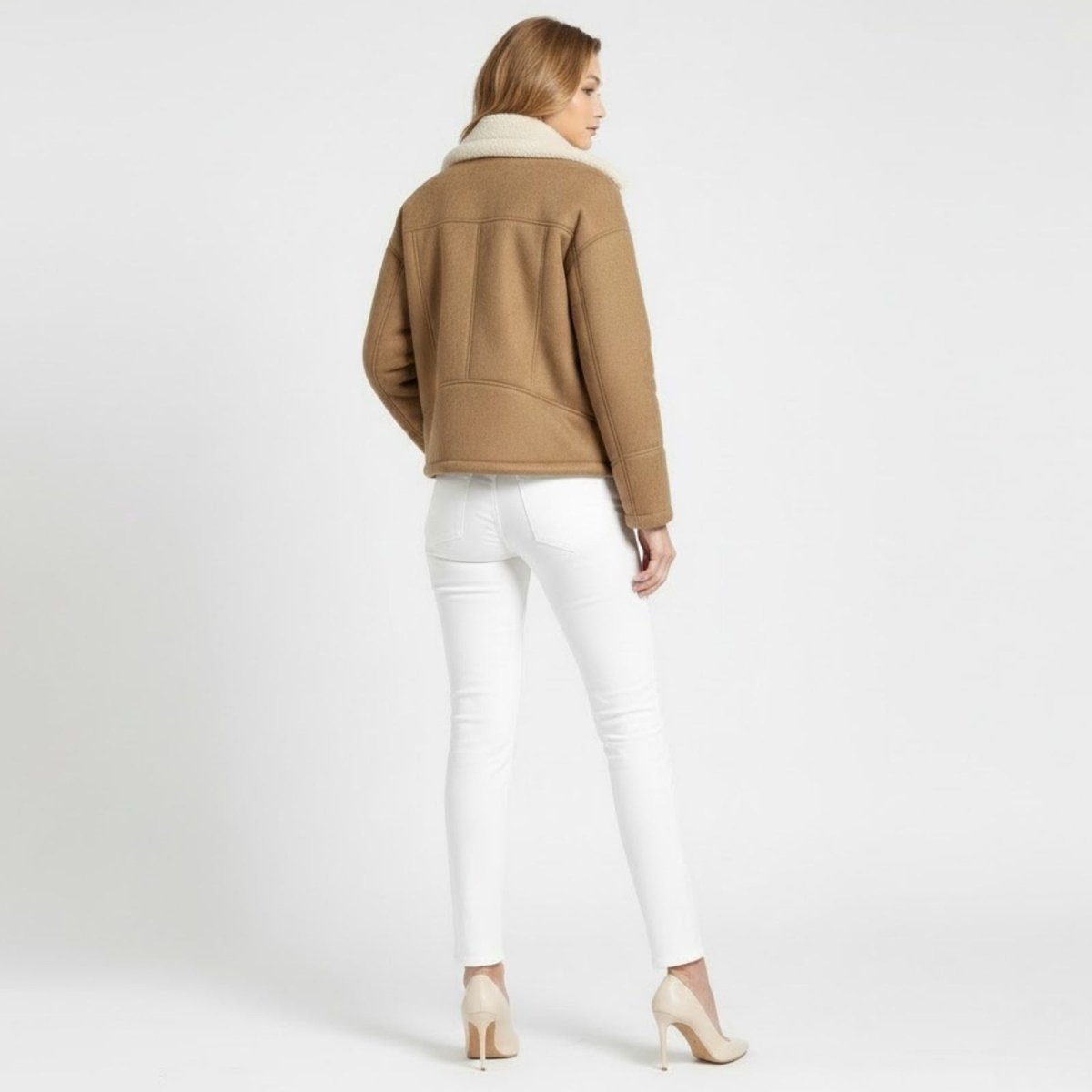 Back view of a woman wearing the Loretta khaki shearling-lined moto jacket from Kouvr, highlighting the structured seam details.
