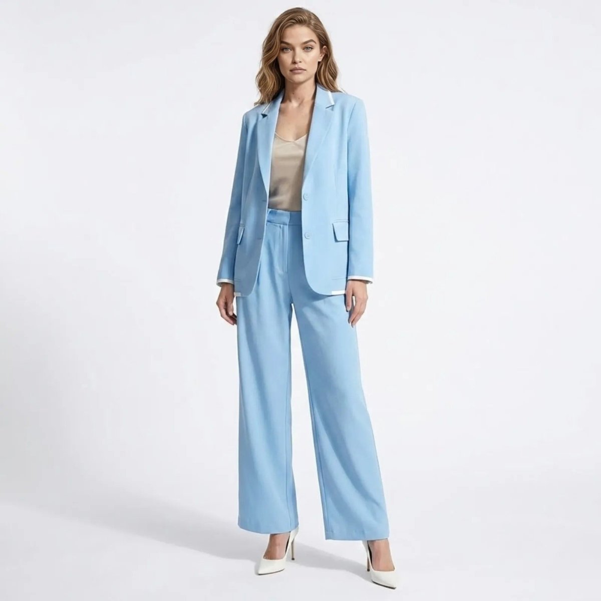 Model wearing the Kouvr Lucia Set sky blue pant suit with a relaxed fit blazer and matching wide-leg trousers, styled with a neutral top and white heels.