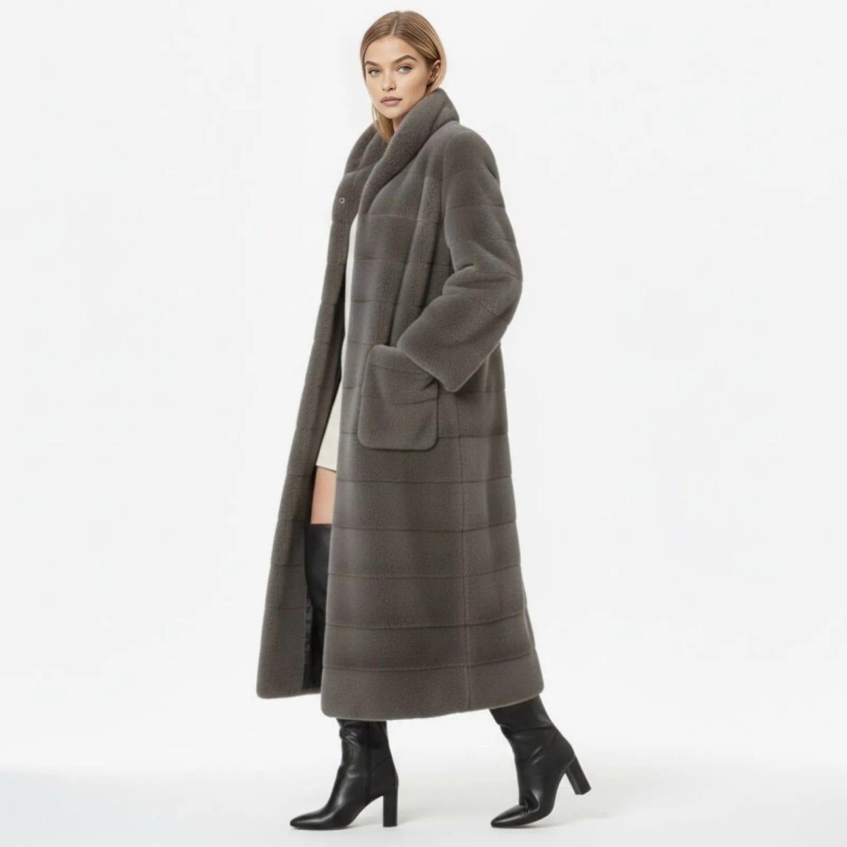 Side profile of a woman walking in a full-length grey faux fur winter coat with large patch pockets, showing its relaxed silhouette.