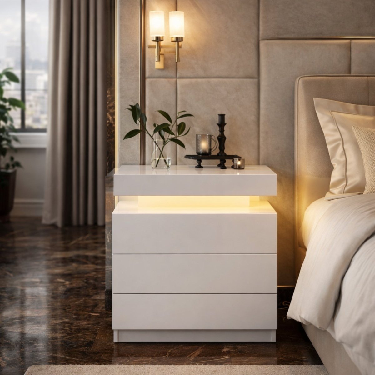 The Kouvr Lumina two-drawer nightstand in a dark grey marble finish with warm integrated LED lighting, positioned beside a bed with dark curtains.
