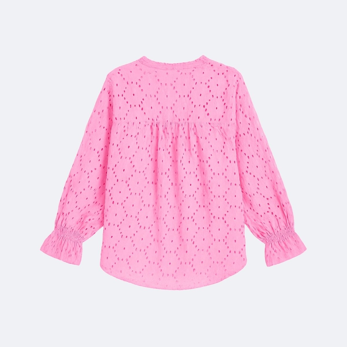 Flatlay product shot of the back of the Kouvr pink eyelet blouse, showcasing the full pattern and curved hem.