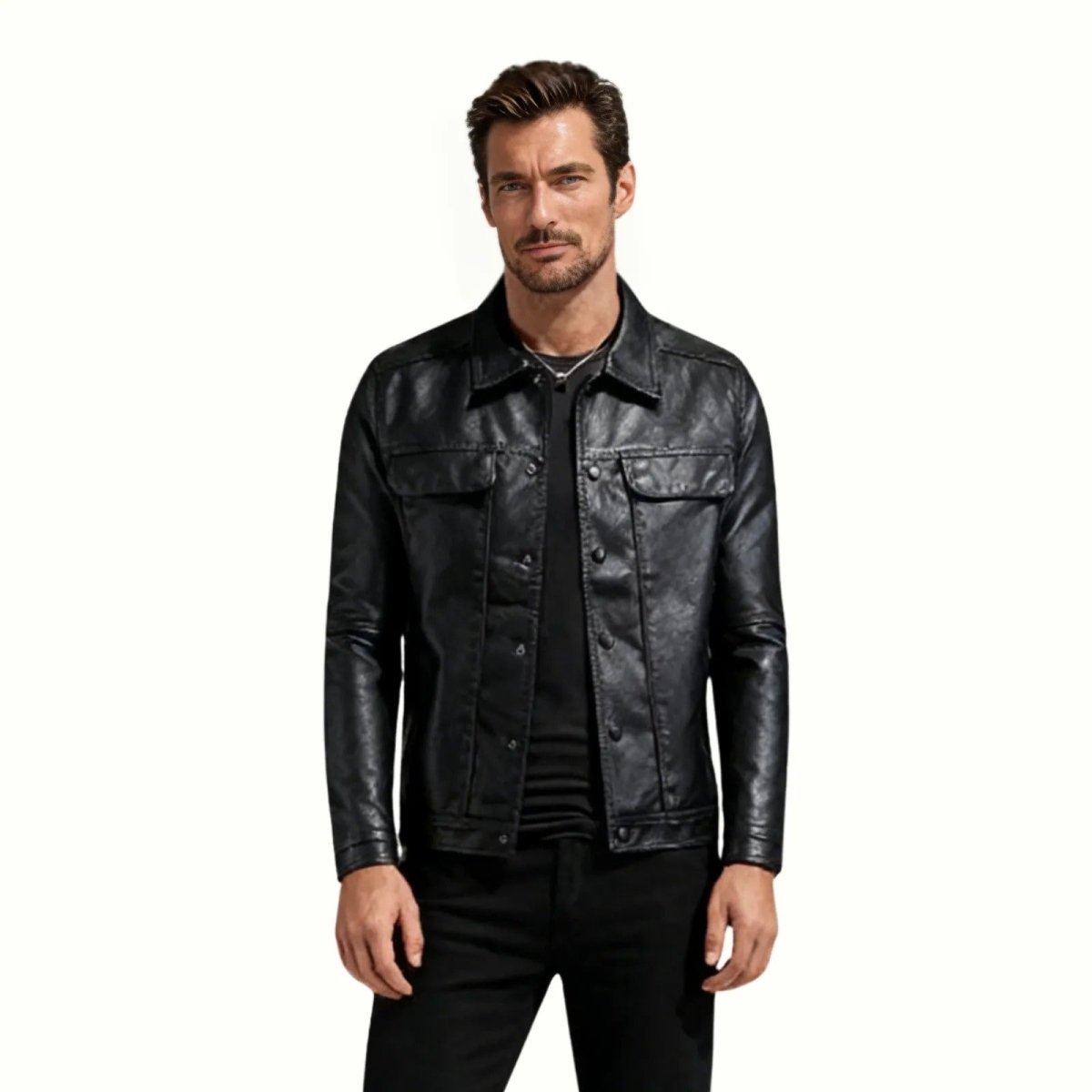 Model wearing the Kouvr men's black leather trucker jacket with a black t-shirt and black jeans, showing the front fit and details.
