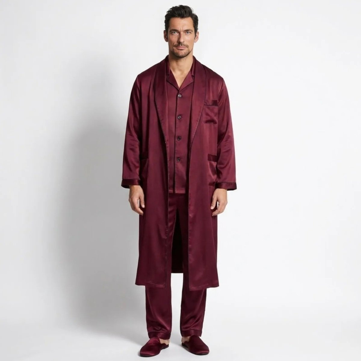 Male model wearing the Kouvr men's 3-piece burgundy silk pajama and robe set, front view.