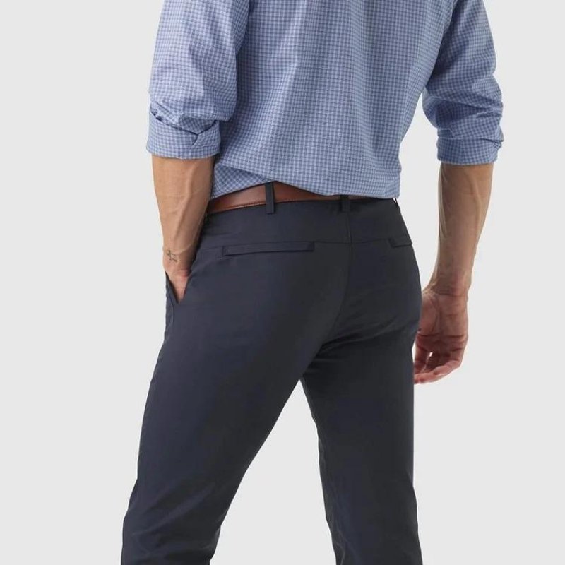 Rear view of a man wearing Kouvr All-Day Commuter Pants in navy, showing the fit and the clean design of the welted back pockets.