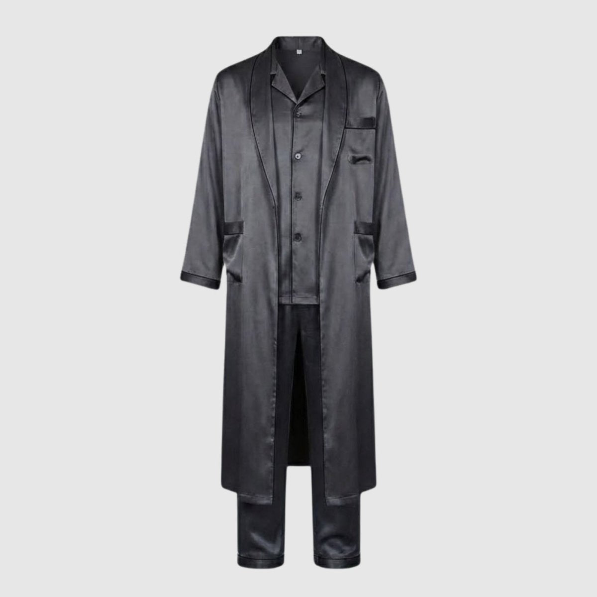 Flatlay of the Kouvr men's three-piece dark grey satin sleepwear set, showing the long robe, button-up shirt, and trousers arranged neatly against a neutral background.