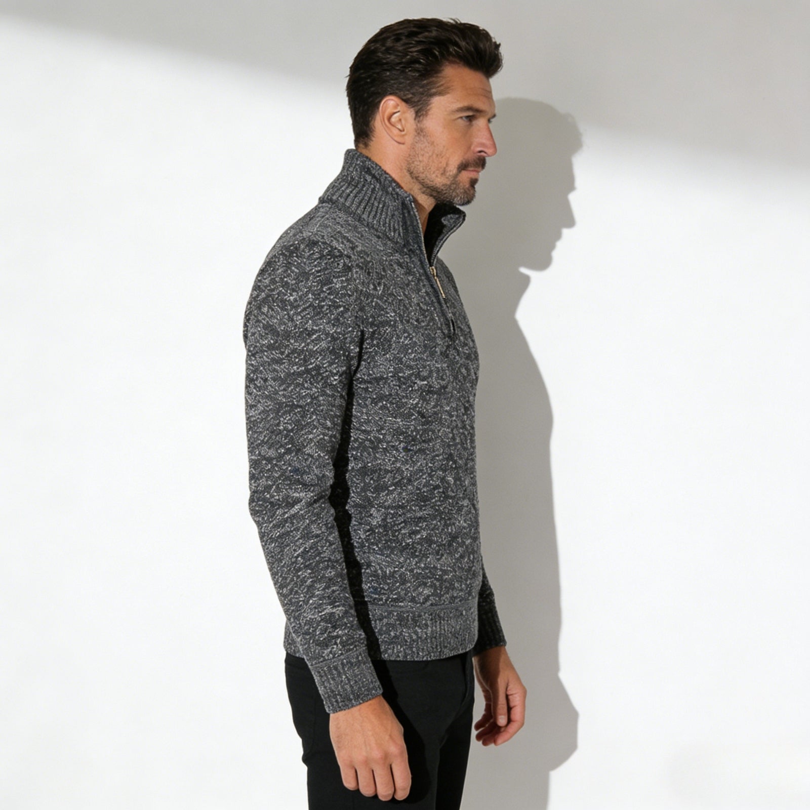 Side profile of a male model in the Kouvr grey quarter-zip funnel neck sweater, highlighting the garment's silhouette.