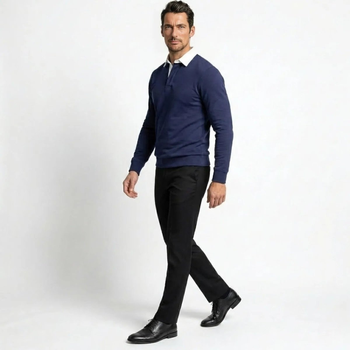 Side profile of a man walking in a navy blue smart casual long sleeve polo, demonstrating the garment's drape and silhouette.