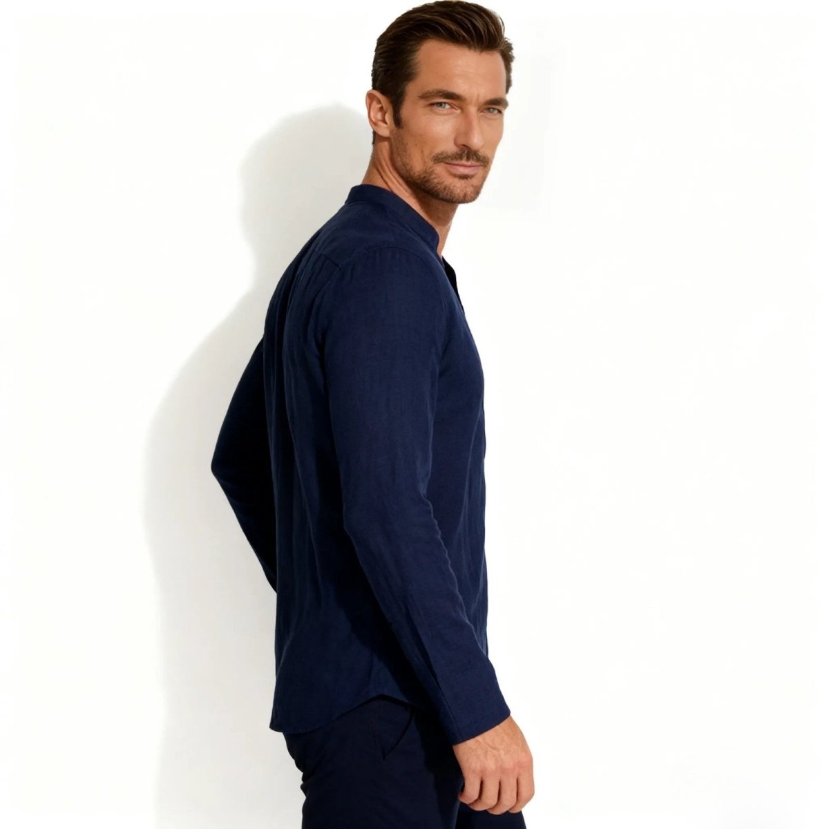 Side profile of a man wearing the Kouvr navy blue breathable linen blend shirt, showing the fit and drape of the fabric.