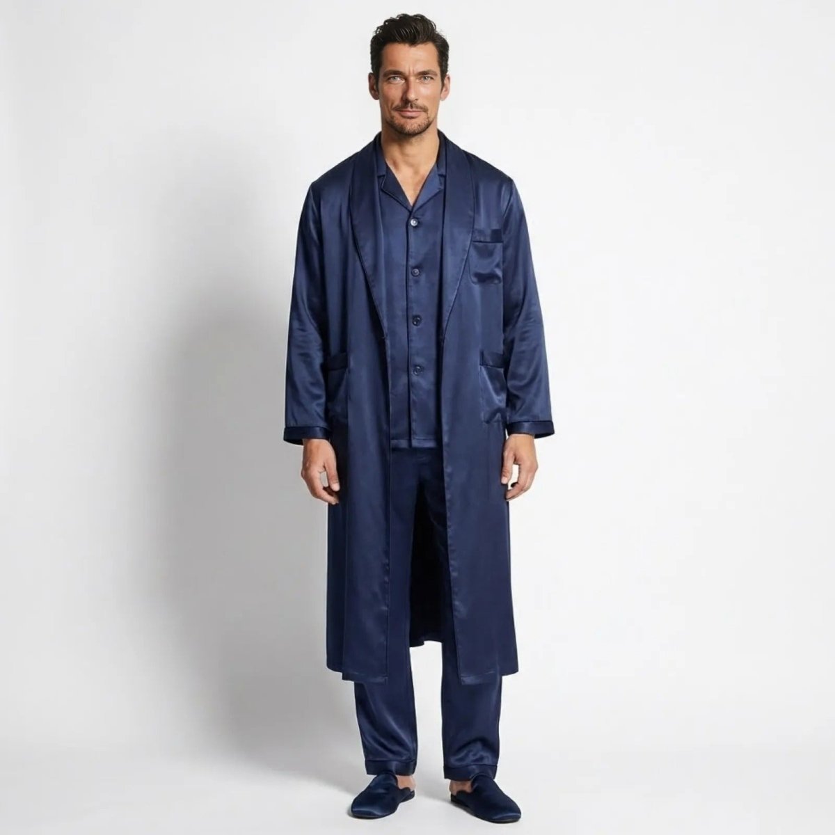 Model wearing the complete Kouvr three-piece navy satin pajama set with a long robe, facing forward against a white background.