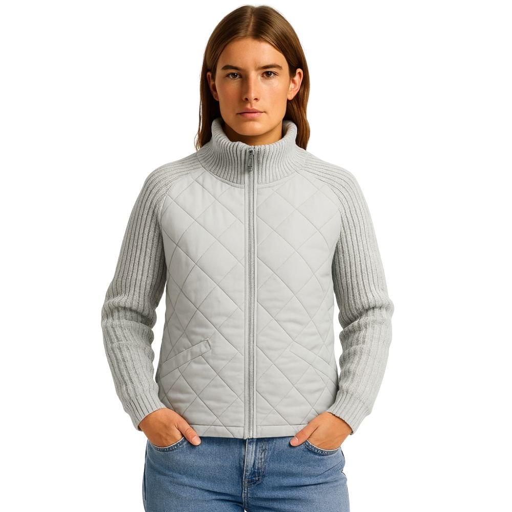 Model wearing the Kouvr Mika hybrid jacket in Heather Gray and Winter White, featuring quilted body and honeycomb knit sleeves, styled with jeans 
