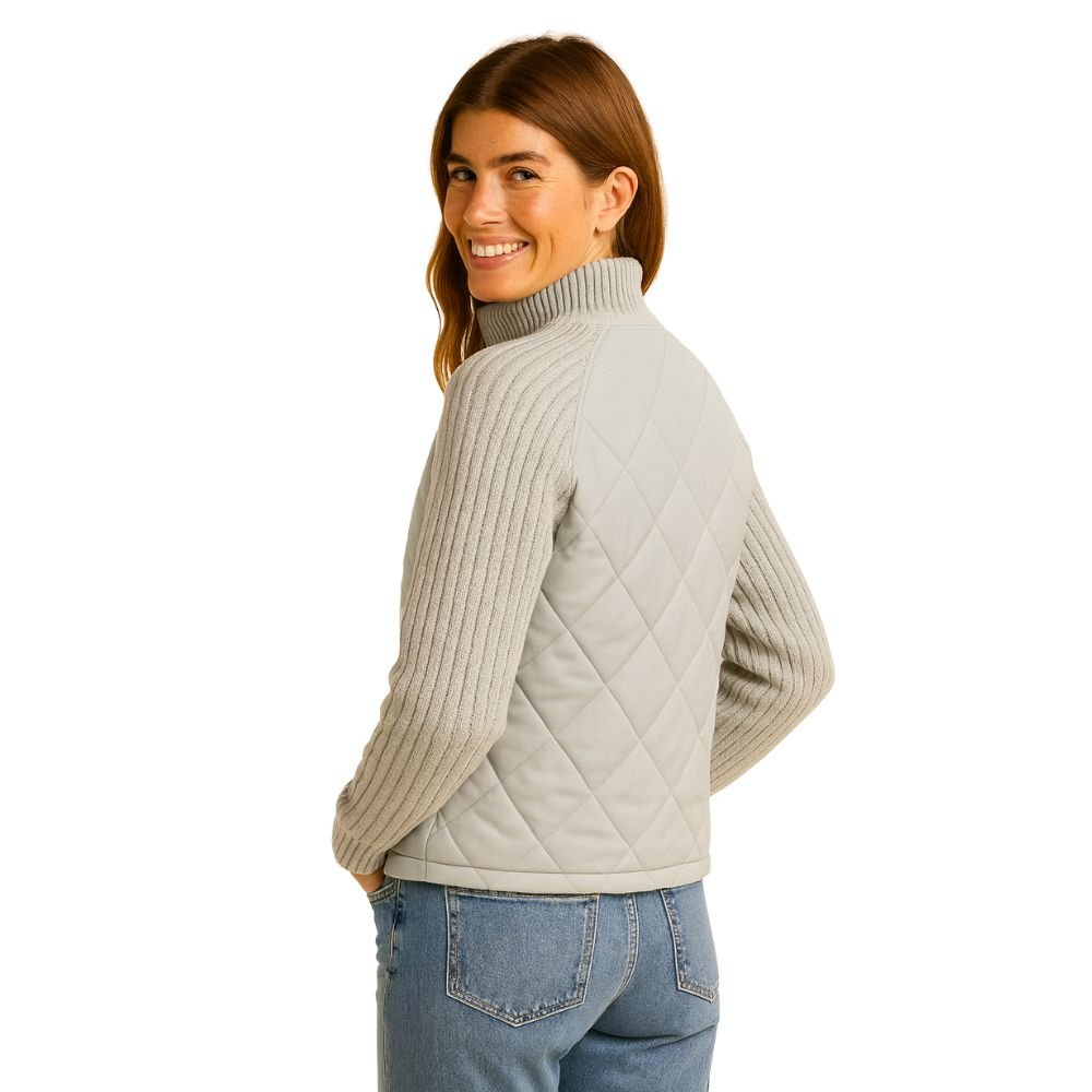 Model wearing the Kouvr Mika hybrid jacket in Heather Gray and Winter White, featuring quilted body and honeycomb knit sleeves, styled with jeans 