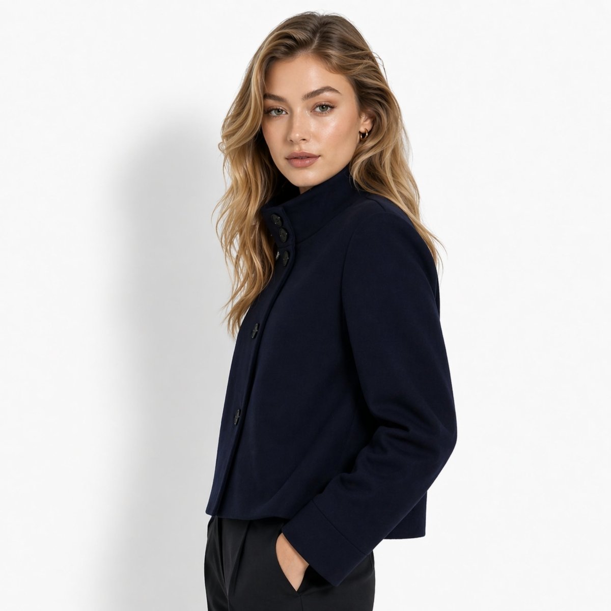 Side profile of blonde woman wearing elegant minimalist navy funnel neck short coat outerwear.
