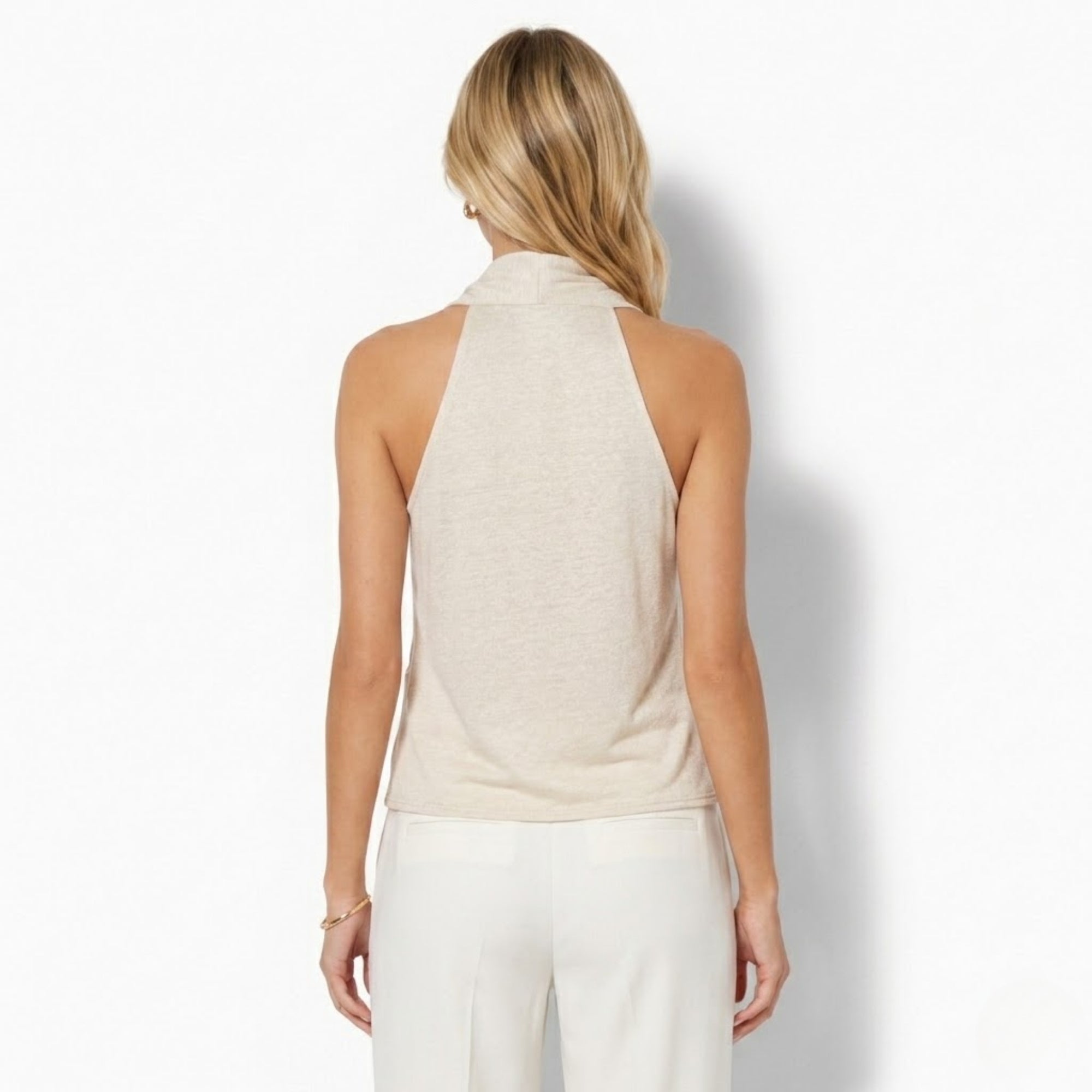 Back view of a minimalist beige sleeveless top showing the sophisticated cutaway shoulder design and clean tailored lines by Kouvr