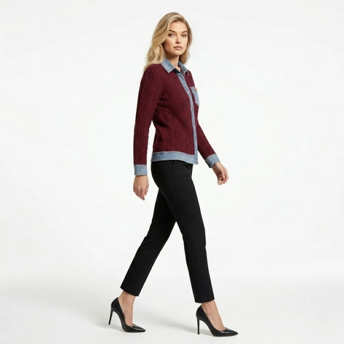 Side profile of woman walking, showcasing the tailored slim fit and denim hem details of the burgundy mixed media button down sweater.