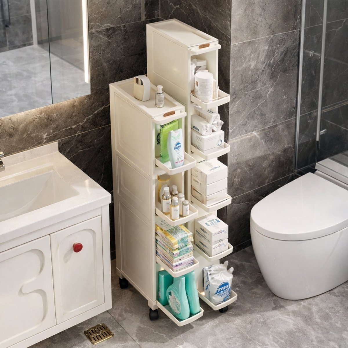Elegant narrow bathroom storage cabinet by Kouvr placed beside a modern white vanity, featuring frosted doors and gold hardware.