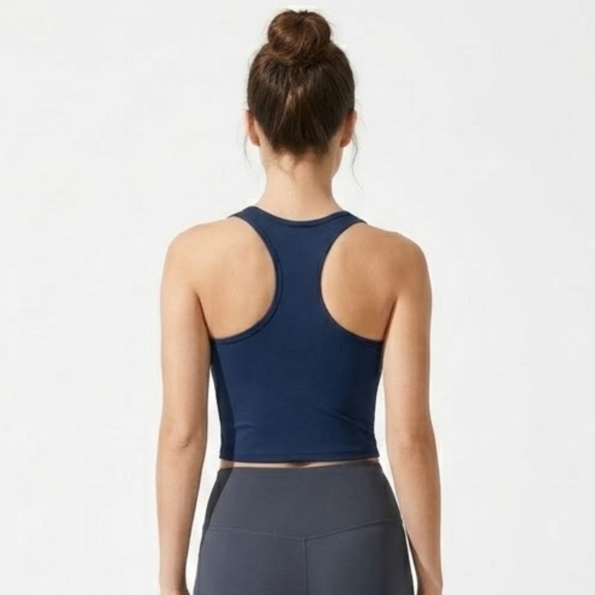 Back view of the Kouvr navy blue racerback activewear crop top showing sculpted fit.