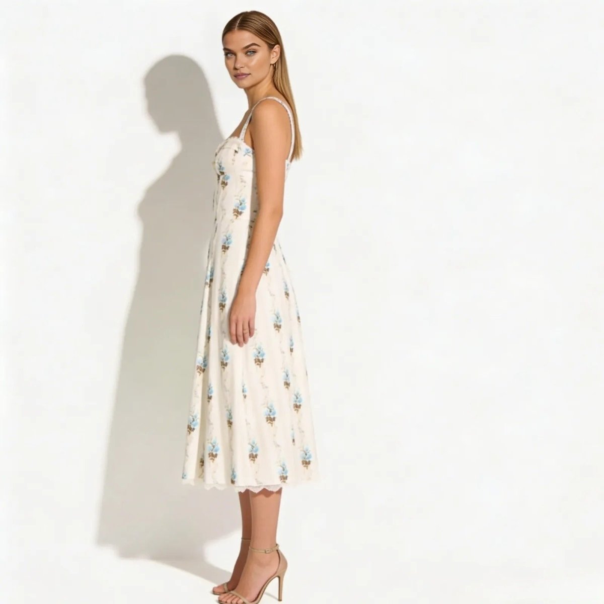 Side profile of a model in the Kouvr Nefeli cream floral bustier midi dress, showcasing the A-line silhouette and midi length.