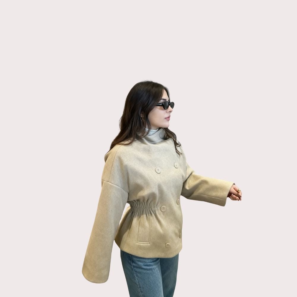 Model wearing the Kouvr oversized oatmeal wool jacket with blue jeans and a brown shoulder bag
