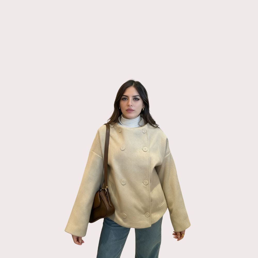 Model wearing the Kouvr oversized oatmeal wool jacket with blue jeans and a brown shoulder bag