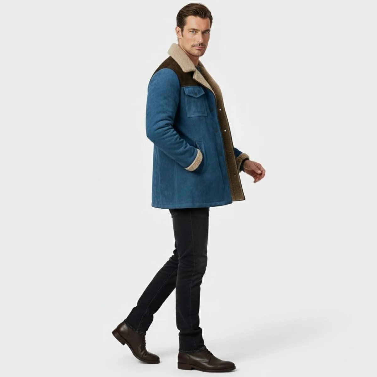 Side profile of a man walking in a slim-fit blue suede and sherpa lined winter coat by Kouvr.