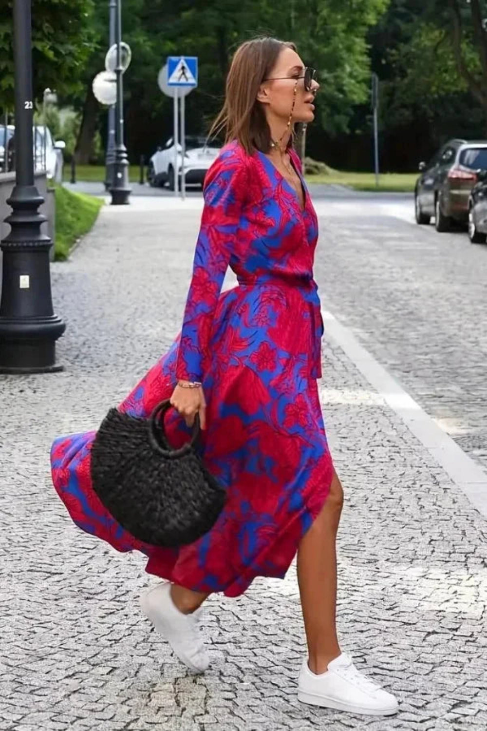 Model walking in Kouvr's red floral long sleeve wrap midi dress