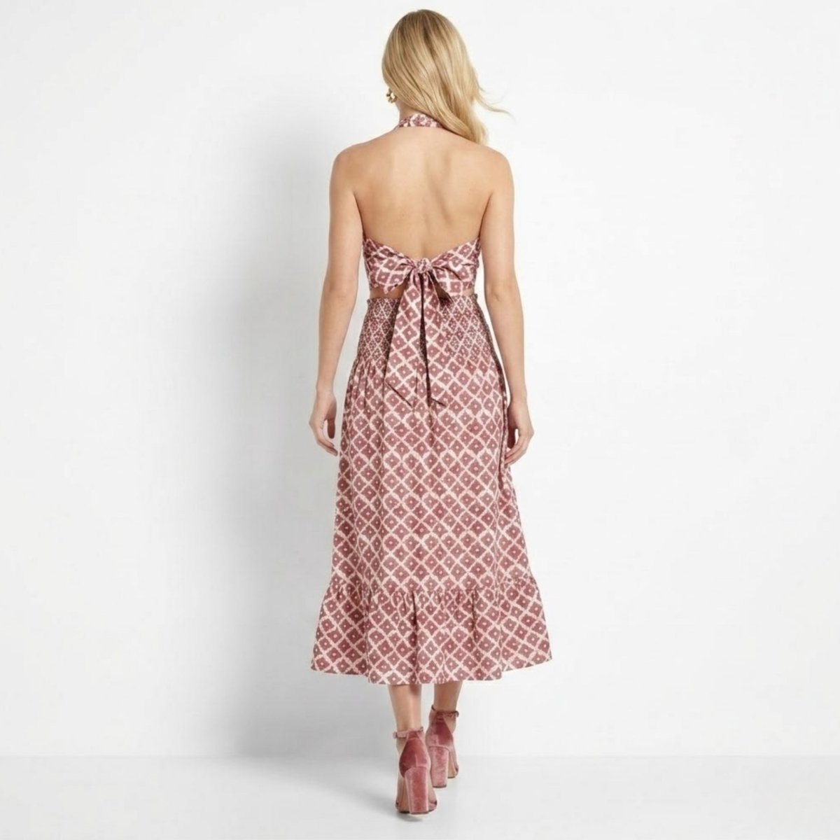 Back view of Kouvr red boho two piece outfit showing large bow tie top and smocked high waist midi skirt.